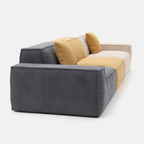 Kivo Modular Sofa shown from a rear side angle with charcoal, mustard, and cream modular sections