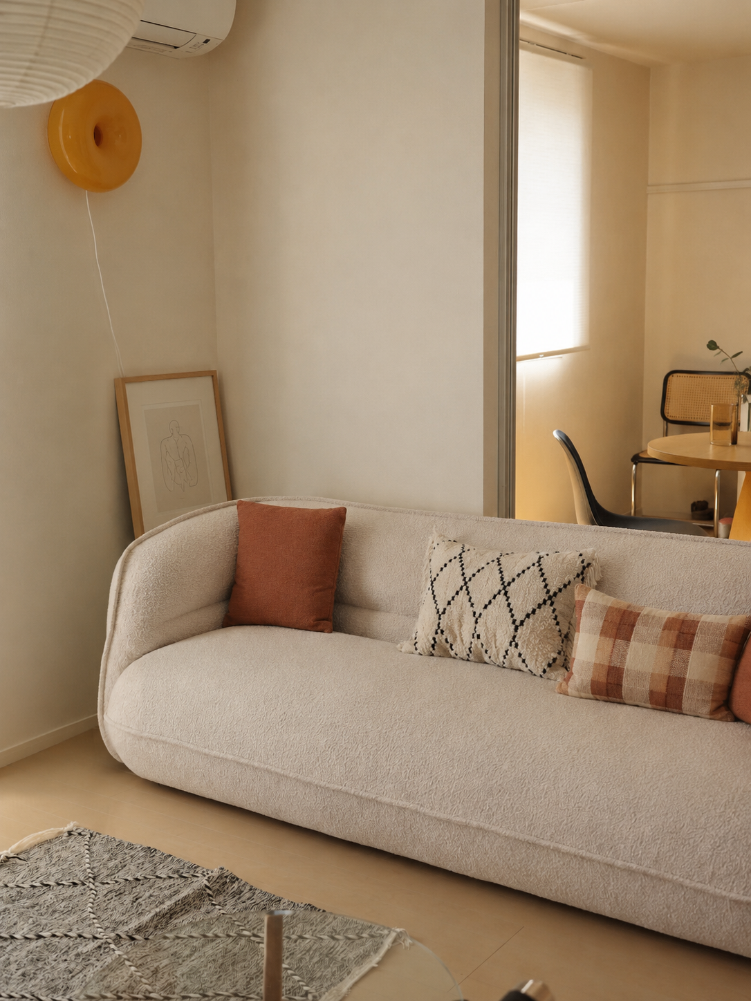 Lune Bouclé Crescent Sofa styled in a cozy apartment living room