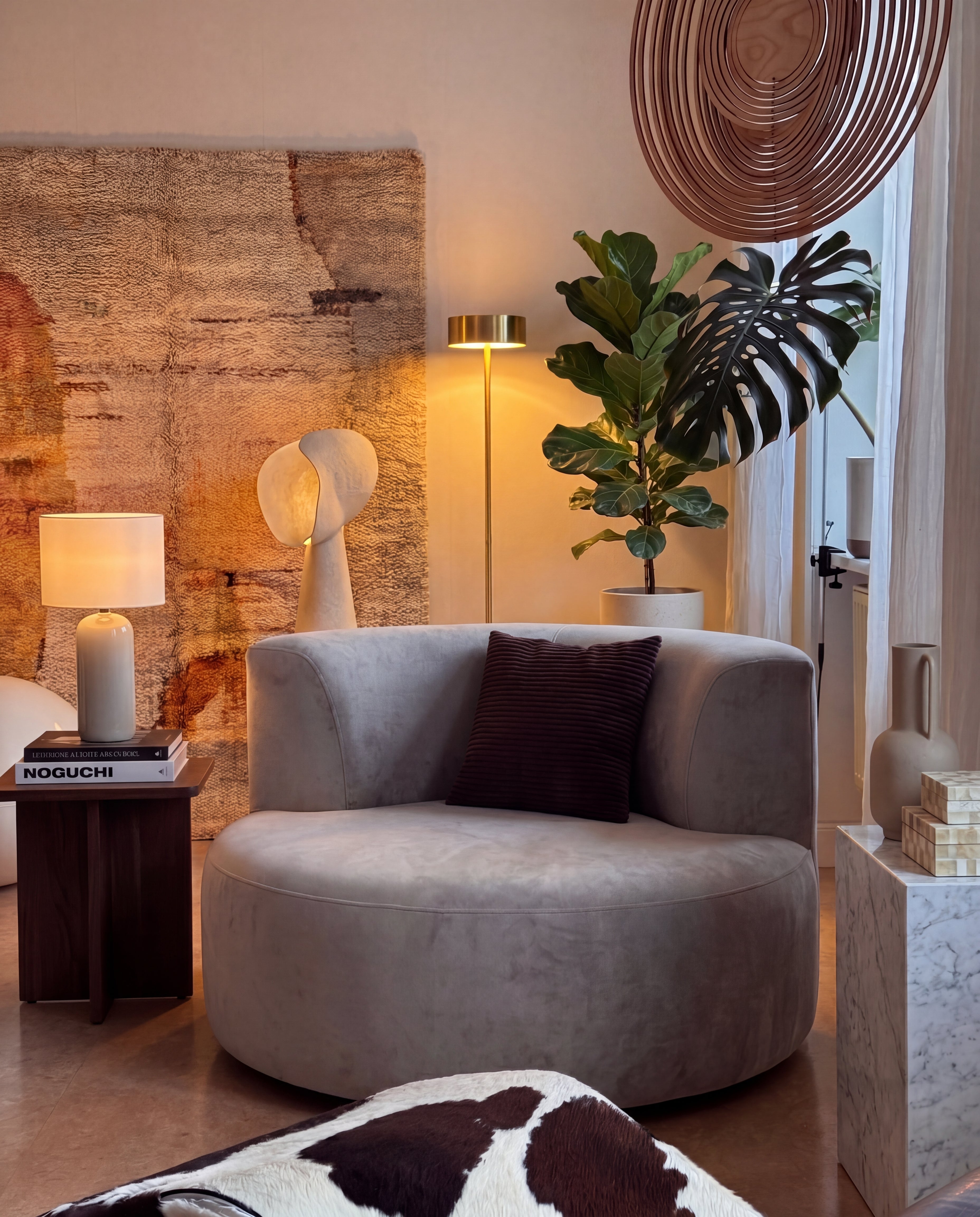 Sola Round Accent Lounge Chair in Light Grey styled in a warm artistic living corner