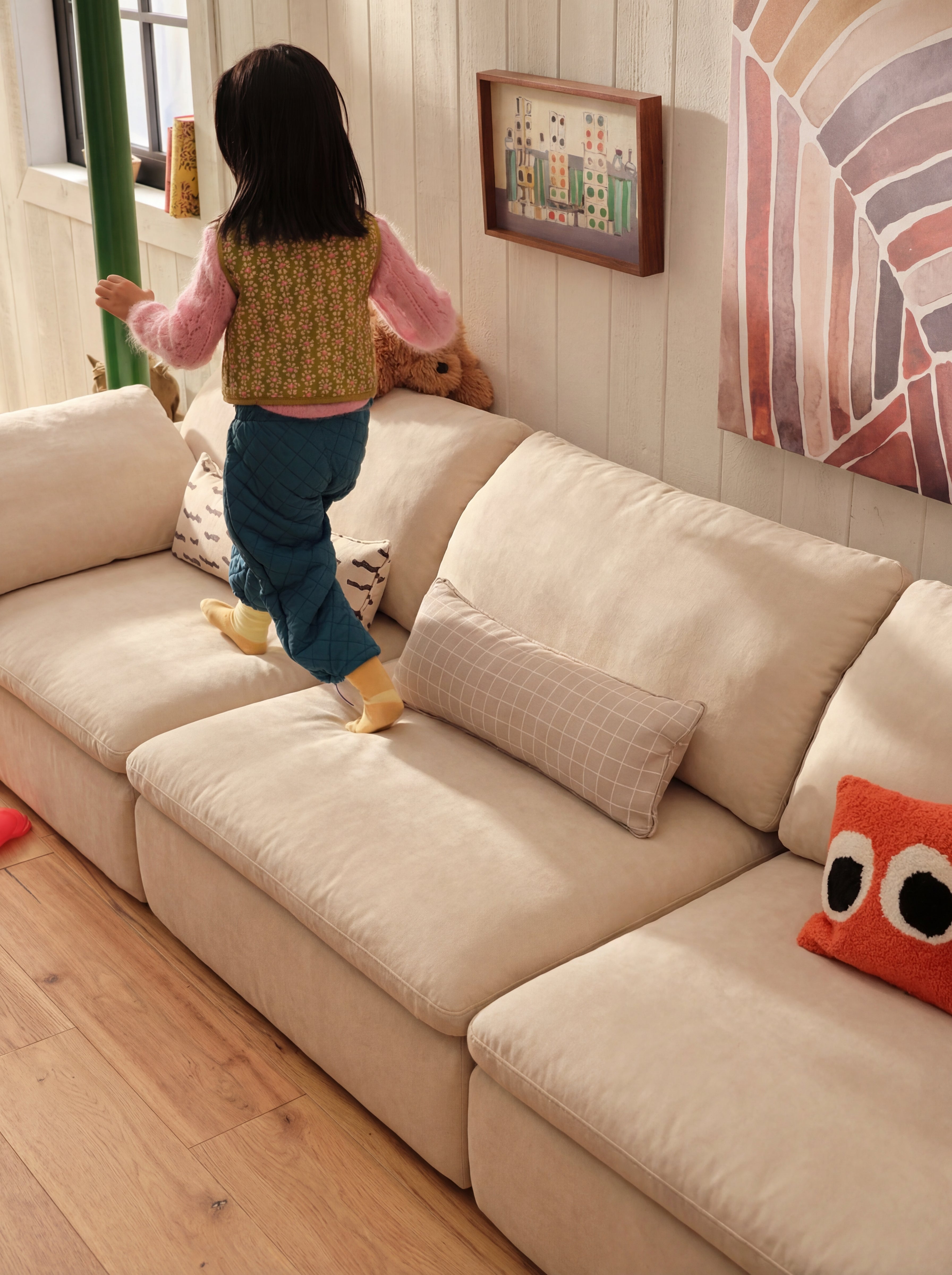 Aero modular sectional sofa in a cozy family living space with a child playing on the cushions