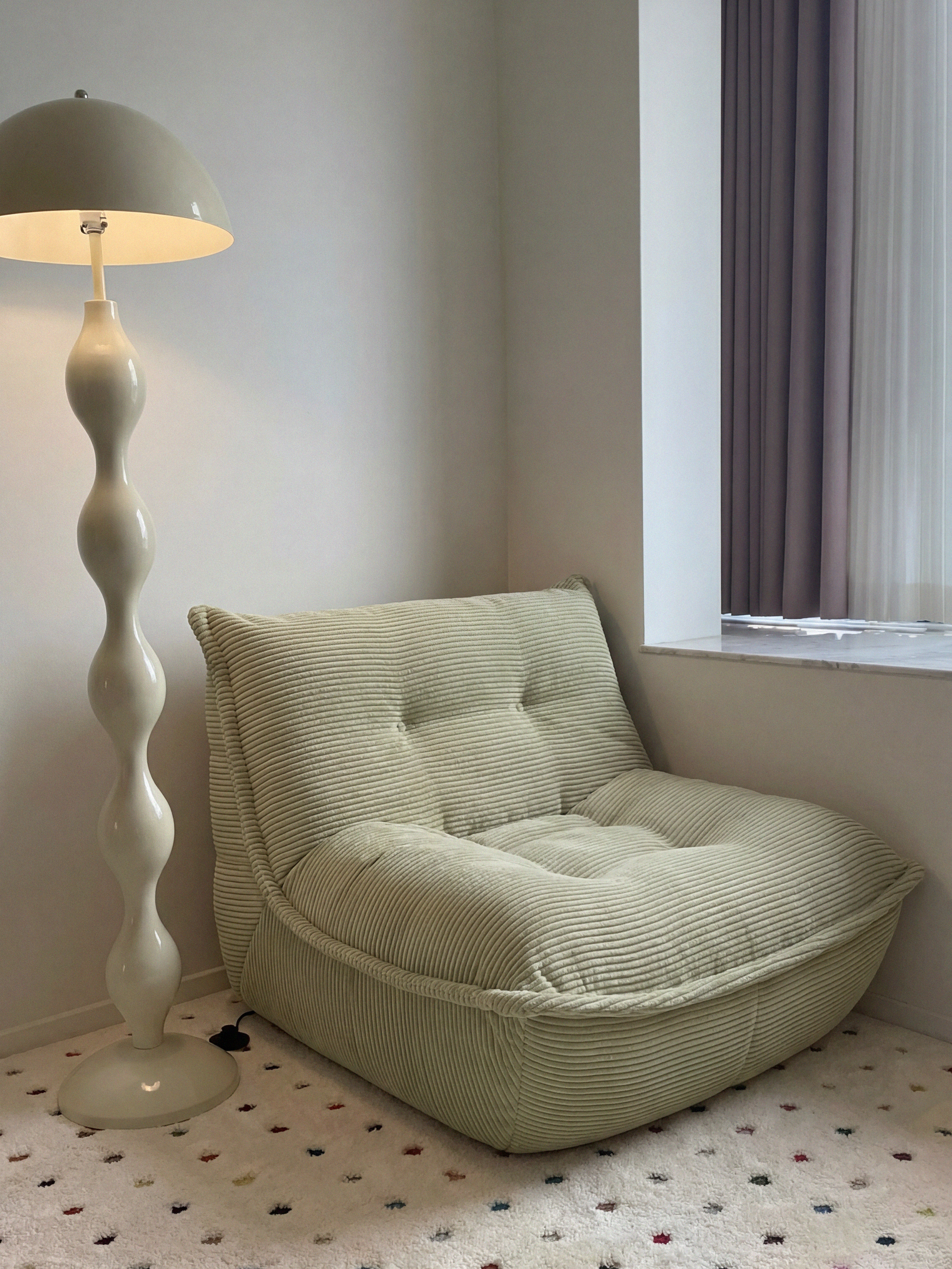 Lune Cream Lounge Chair in Moss styled in a cozy reading corner