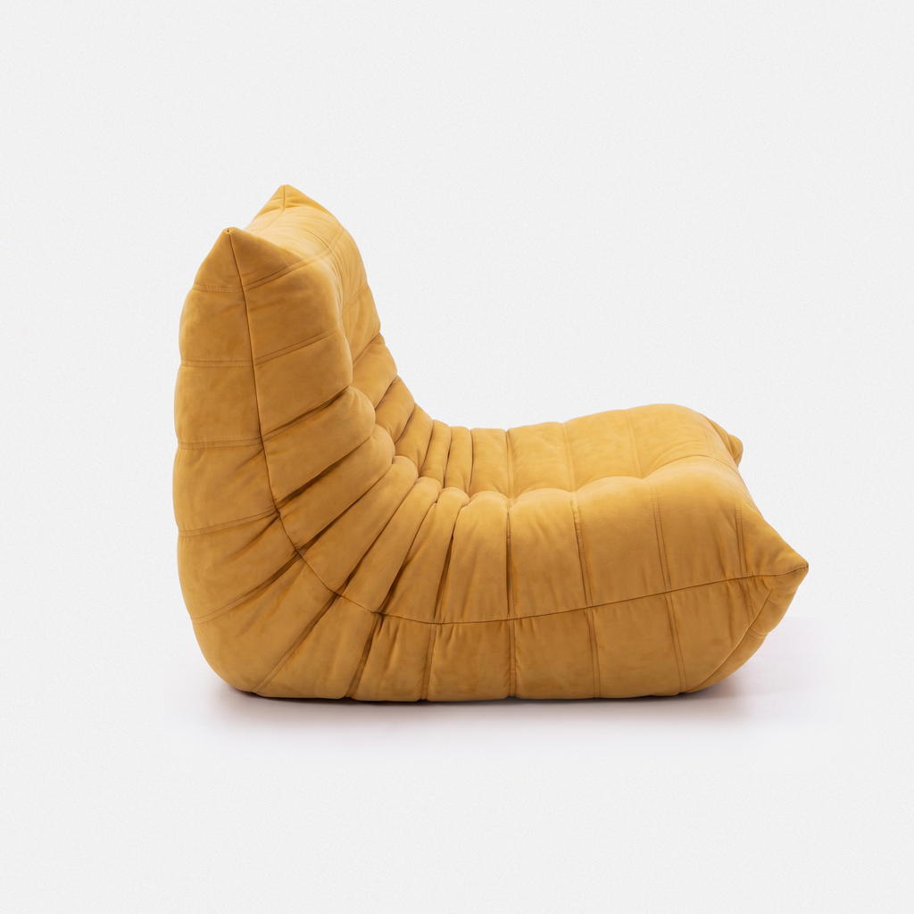 Noma Floor Lounge Chair side view with curved low-profile shape and pleated cushion designshape