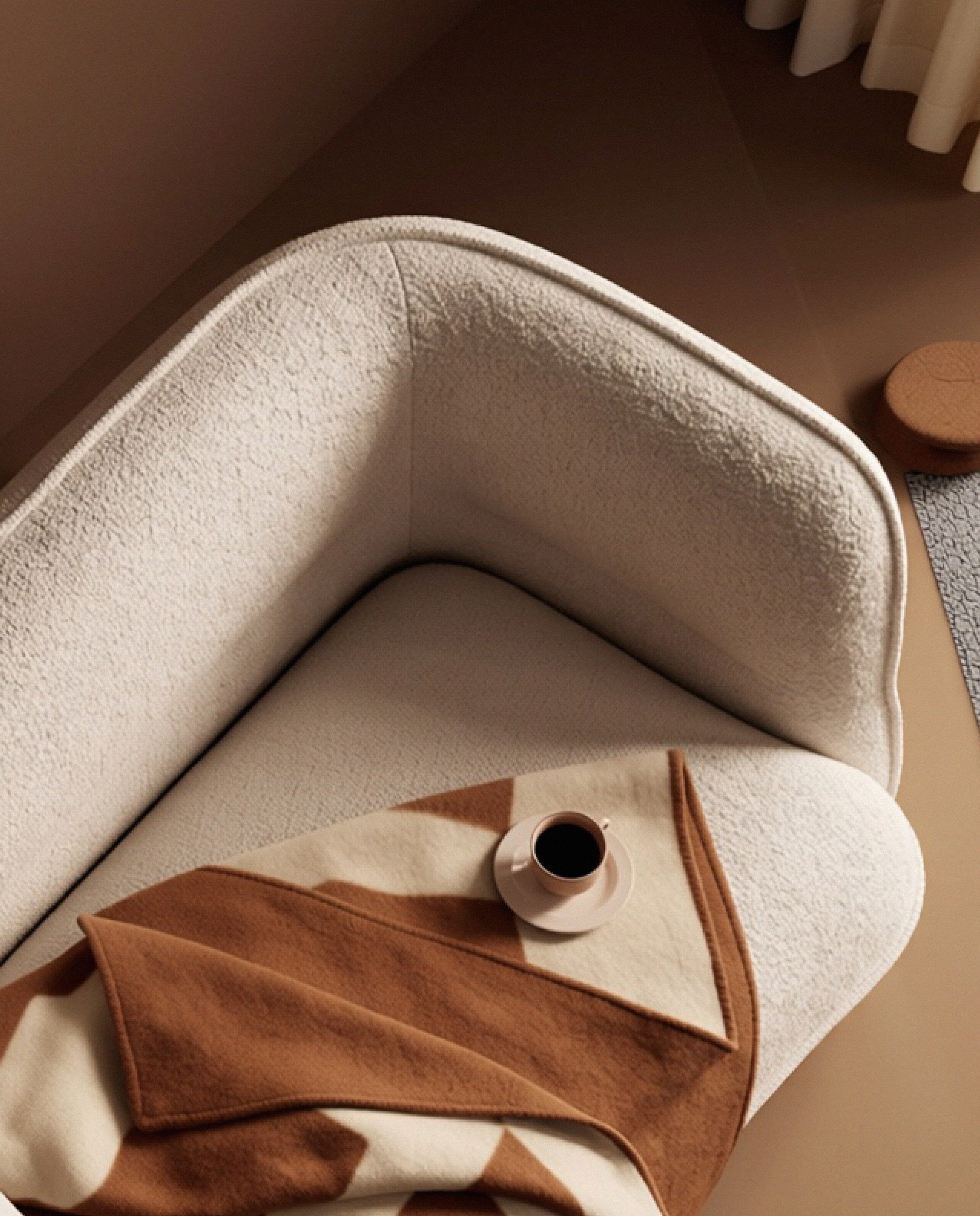 Lune Bouclé Modular Curved Sofa module styled with a blanket and coffee cup