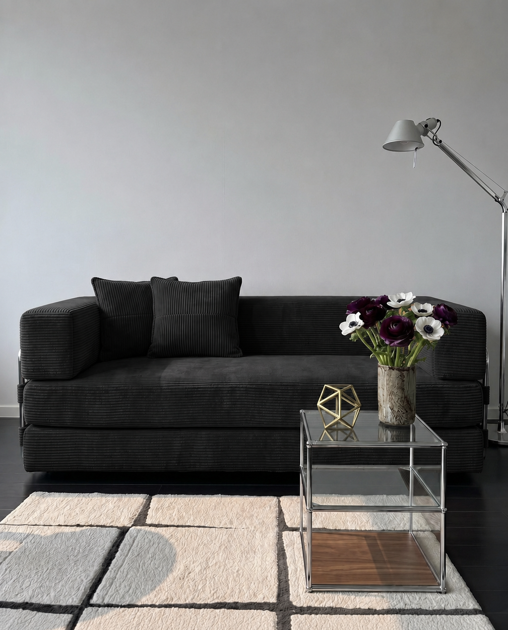 Milo Corduroy Sleeper Sofa in Black styled in a modern living room with glass side table and floor lamp