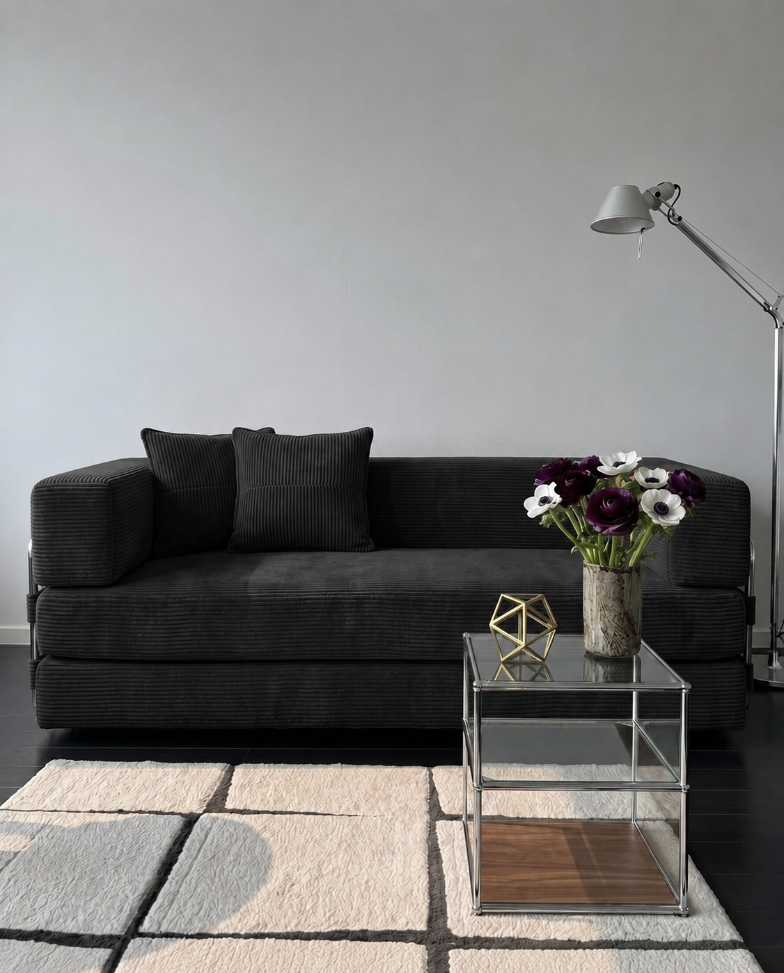 Milo Corduroy Sleeper Sofa in Black styled in a modern living room with glass side table and floor lamp