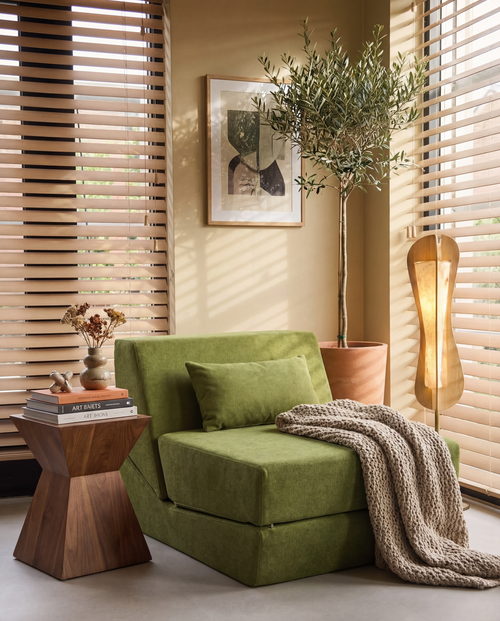 Convertible Lounge Chair Bed in Moss styled in a warm cozy reading corner